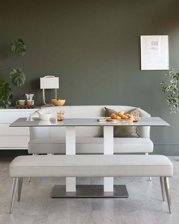 Contemporary dining set with grey table, white bench and sofa. Sleek and stylish for modern dining spaces.