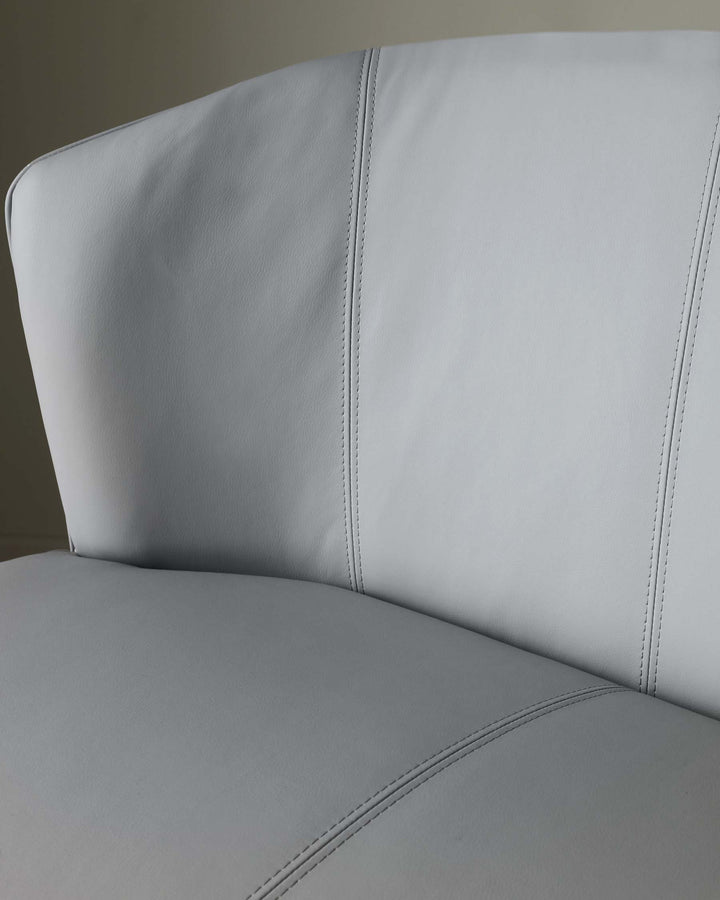 Close-up of a light grey chair with stitching. Ideal for a modern dining or living space.