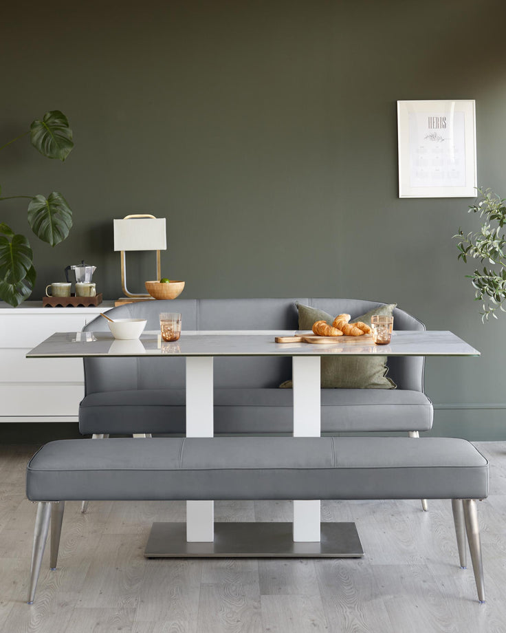 A stylish dining set with a grey table, bench, and banquette seating, creating a modern and inviting dining space.