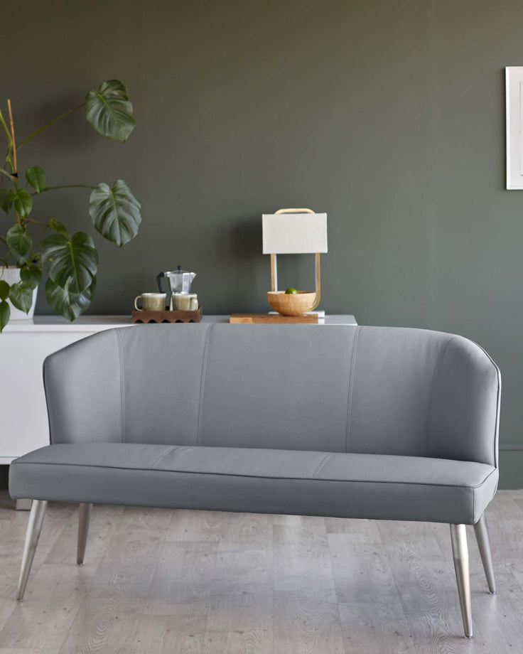 A stylish grey faux leather bench with slender metal legs, ideal for modern living spaces.