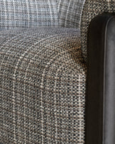 Close-up of Miles Occasional Chair showing Grey textured fabric upholstery and black leather armrest detail.