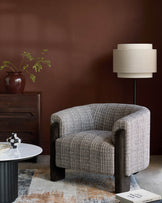 Miles occasional chair in grey textured fabric with dark wooden arms and legs, shown in a styled living room setting.