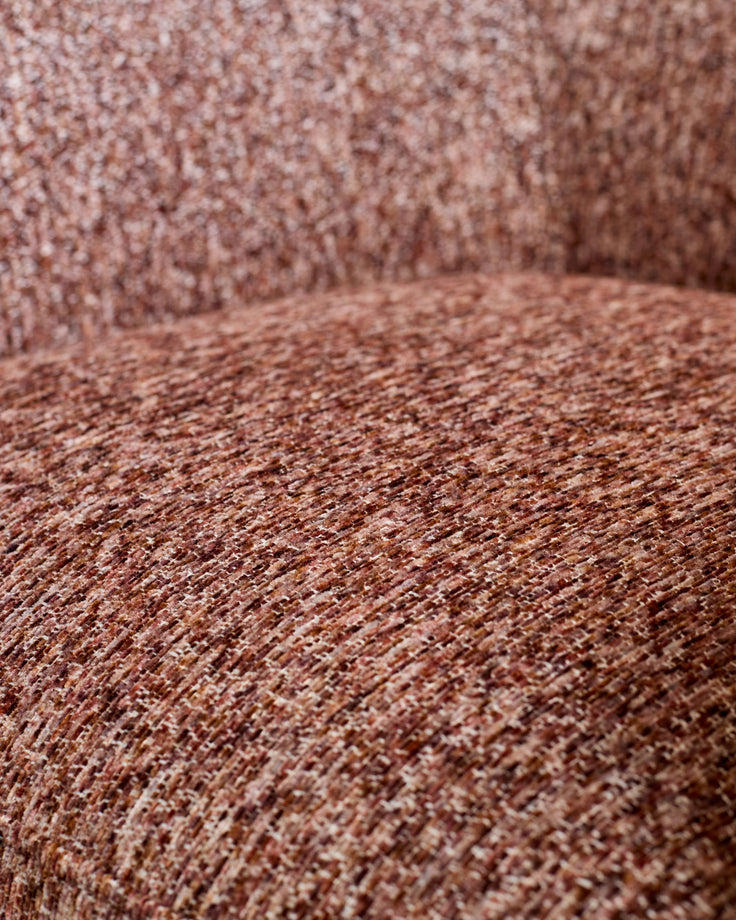 Close-up of toffee-red velvet fabric showing textured weave and soft pile detail.