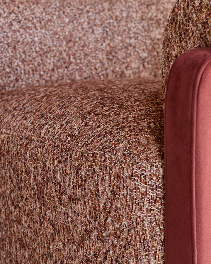 Miles occasional chair in toffee red fabric with velvet finish, showing textured upholstery and curved armrest detail.