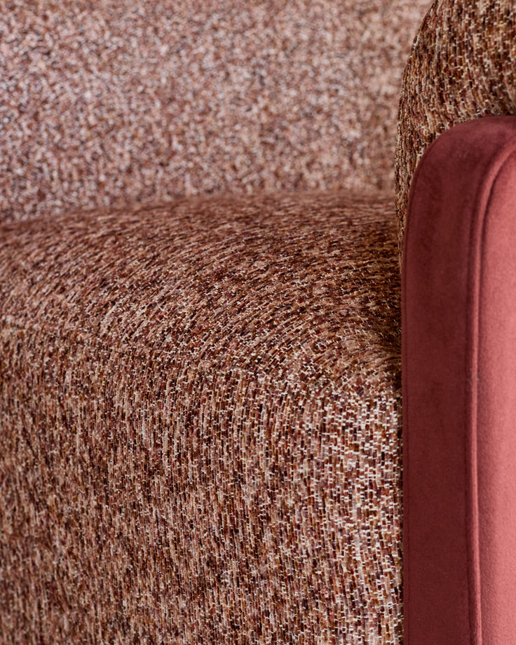 Miles occasional chair in toffee red fabric with velvet finish, showing textured upholstery and curved armrest detail.