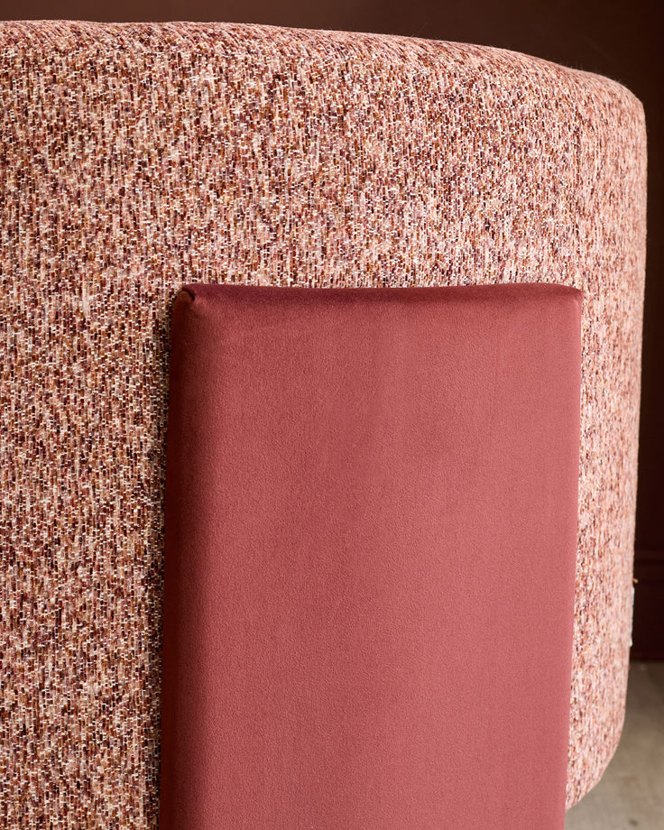 Miles Occasional Chair in toffee red fabric, showing curved cylindrical shape with textured weave upholstery and smooth velvet armrest detail.