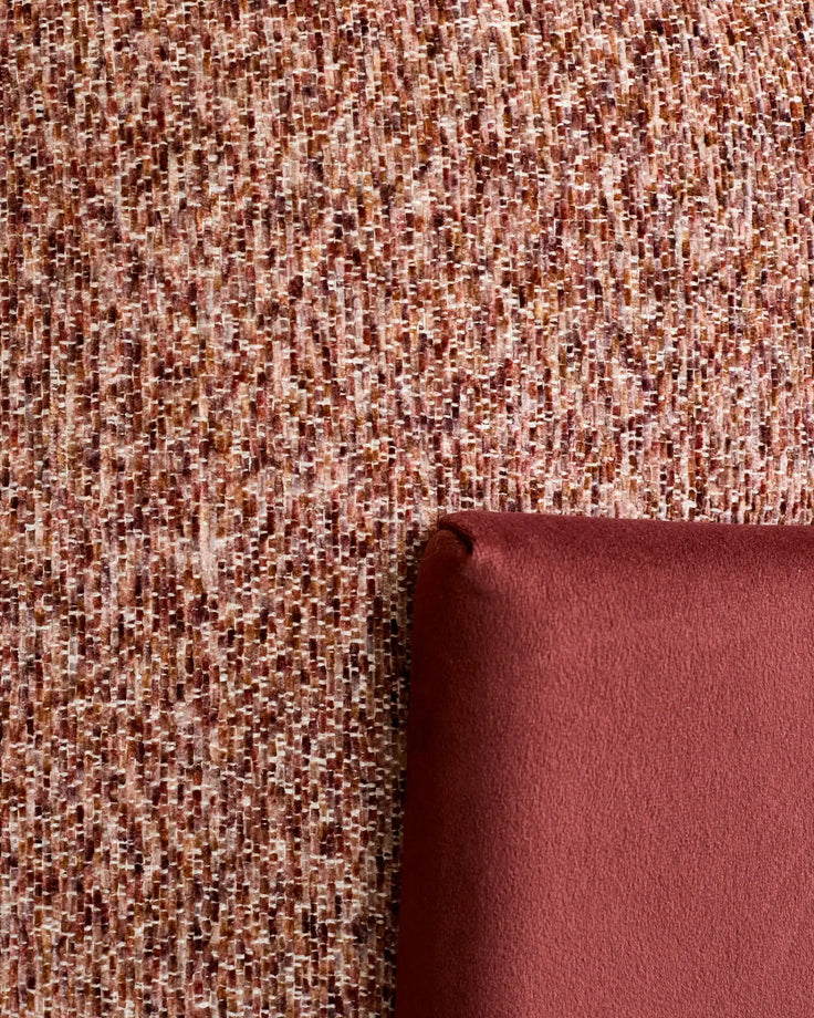 Close-up of toffee-red textured fabric with rolled edge detail showing weave pattern and color variation.