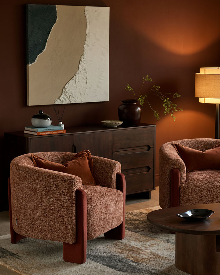 Miles occasional chair in toffee fabric with red wooden legs, shown in warm-toned room setting.