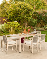 Minori natural wood garden dining bench with cream fabric cushion, shown in outdoor patio setting with matching dining chairs and table.