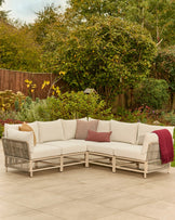 Minori natural garden corner bench set with cream cushions on patio, wooden frame with rattan-style sides and decorative pillows.