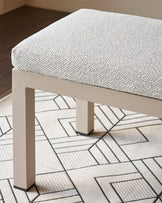 Minori Garden 3-seater dining bench in natural fabric, shown from above with geometric patterned rug underneath.