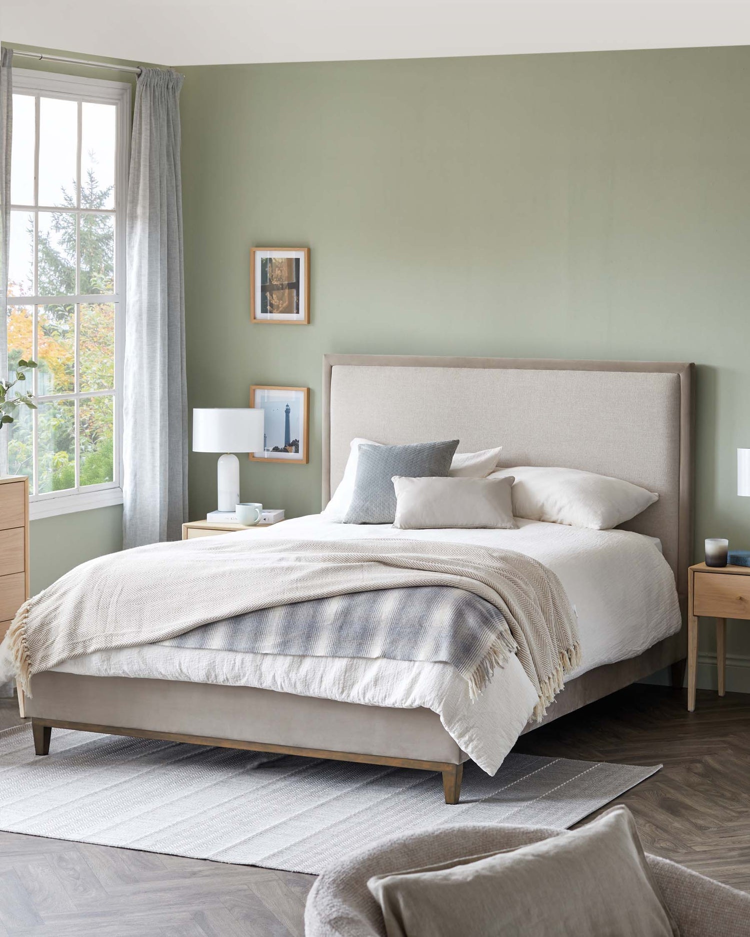 Bedroom with upholstered bed, wood side tables, and grey rug. A restful and stylish interior for a relaxing sleep.