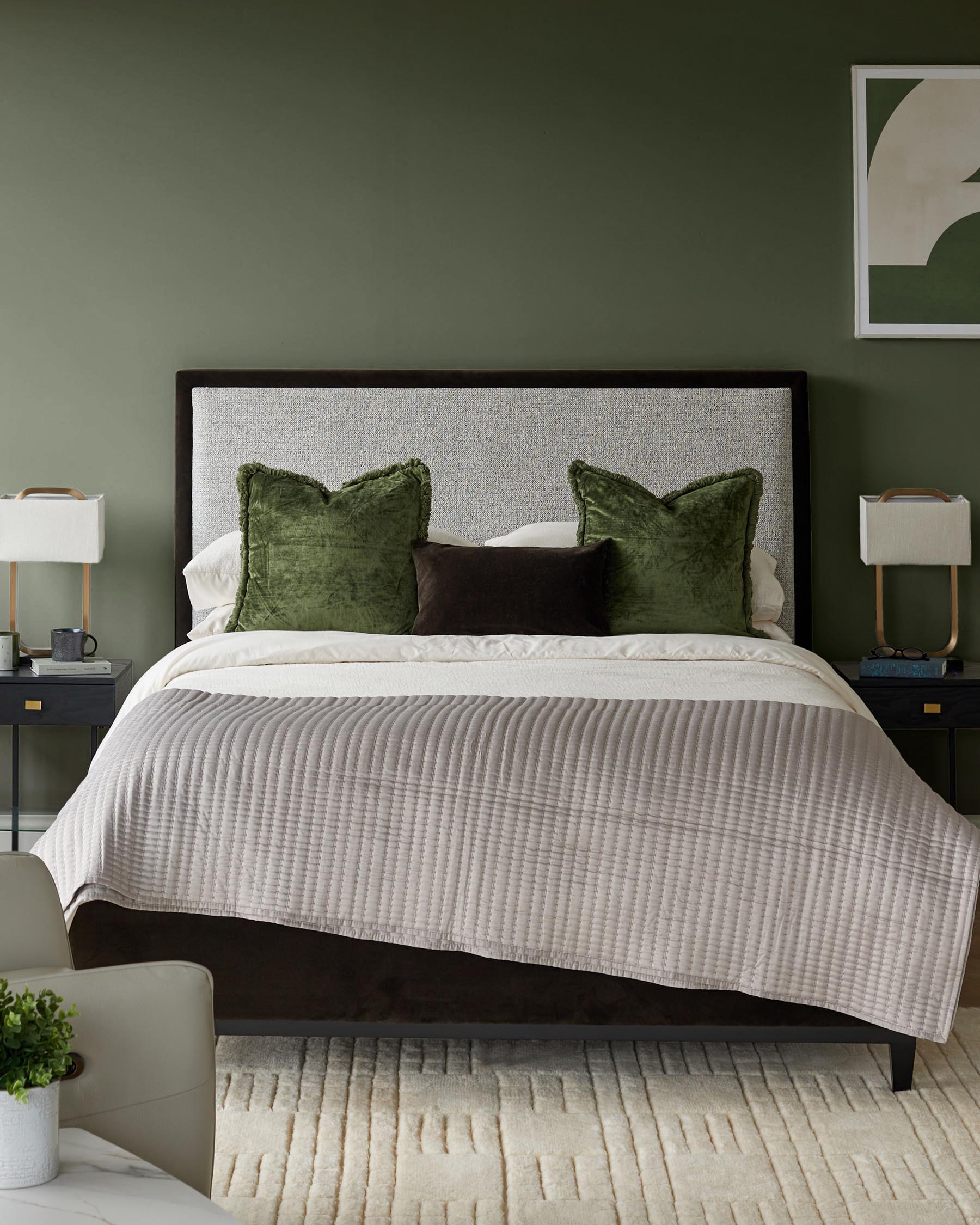 Bedroom with a bed with olive green and brown pillows, with bedside tables and a patterned rug.