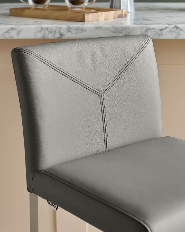 Close-up of a stylish, grey faux leather bar stool, perfect for adding a modern touch to any kitchen or bar area.