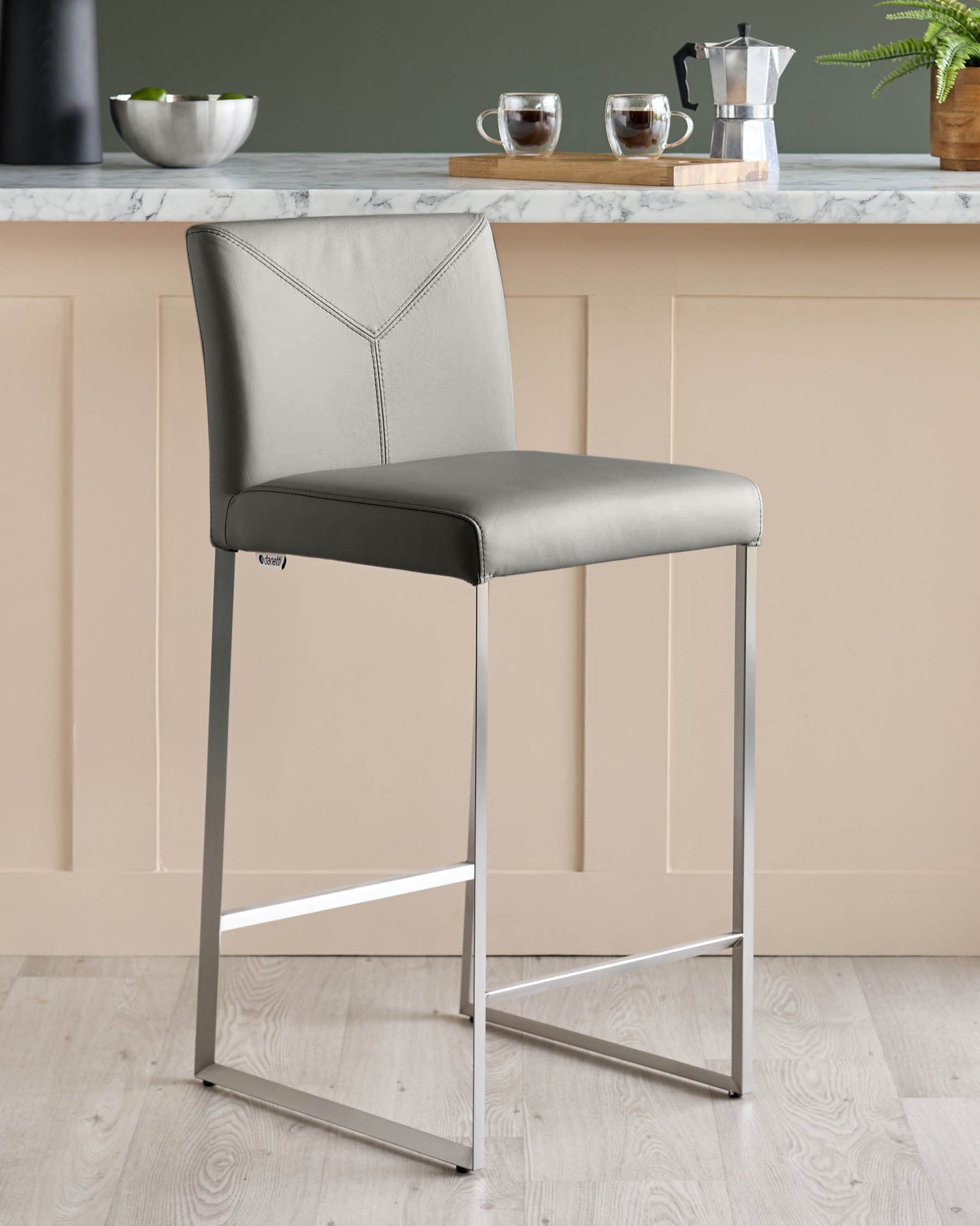 A contemporary grey bar stool with a metal frame, perfect for a modern kitchen.