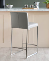 Grey faux leather bar stool with metal frame, perfect for a modern kitchen or bar area.