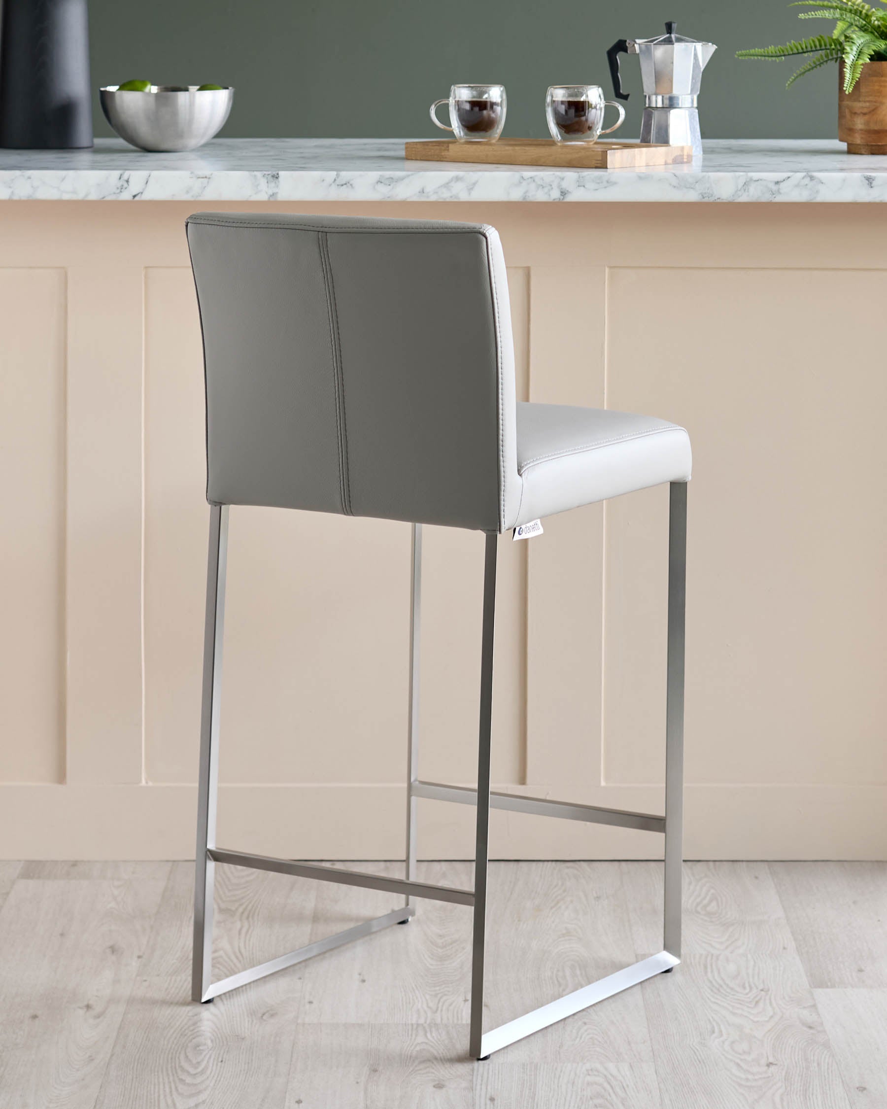 Grey faux leather bar stool with metal frame, perfect for a modern kitchen or bar area.