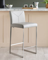 A stylish grey bar stool with a sleek, minimalist design, perfect for adding a touch of modern elegance to any kitchen or bar area.