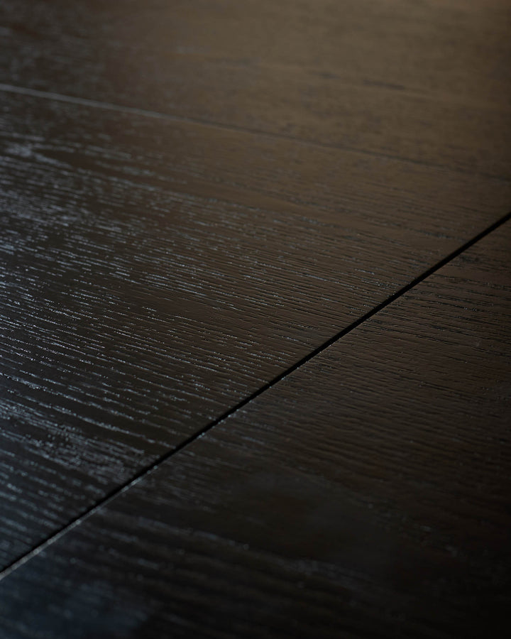 Dark wood dining table surface with wood grain texture and seam detail, close-up view