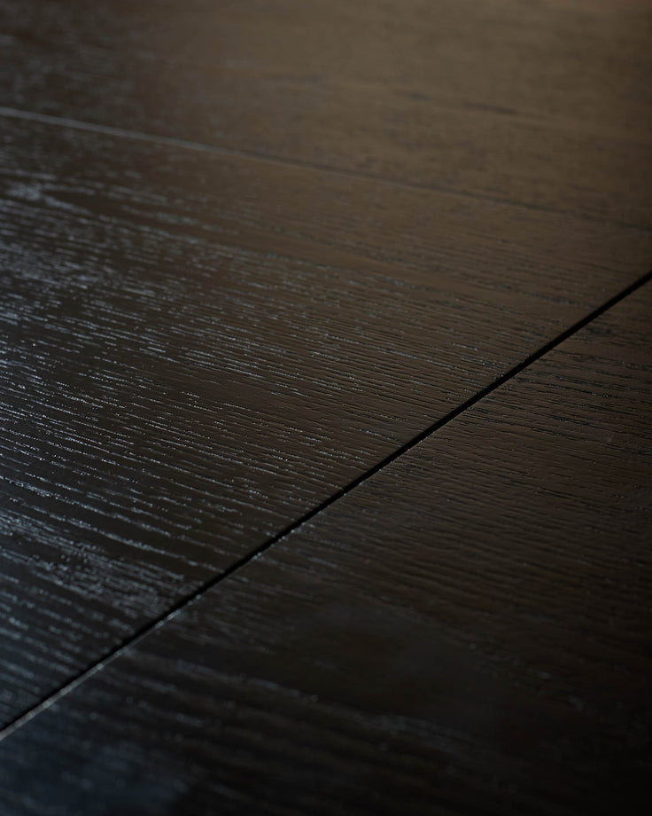 Dark wood dining table surface with wood grain texture and seam detail, close-up view