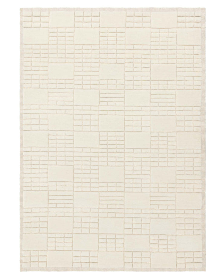Ivory coloured area rug with a geometric pattern consisting of raised squares and rectangles against a flat background.