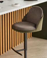 Myra gas lift bar stool in mocha velvet and olive green, shown at a kitchen counter with vertical wood slat detailing.