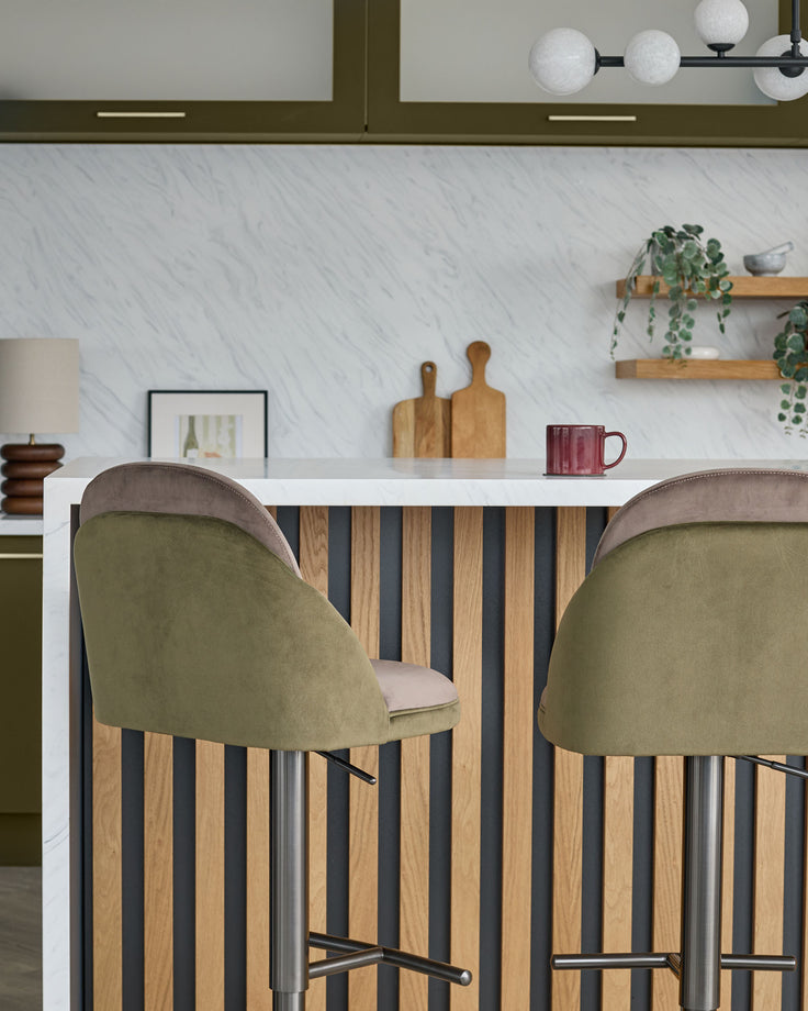 Myra gas lift bar stools in olive green velvet with mocha backs, shown at a striped wood kitchen island.