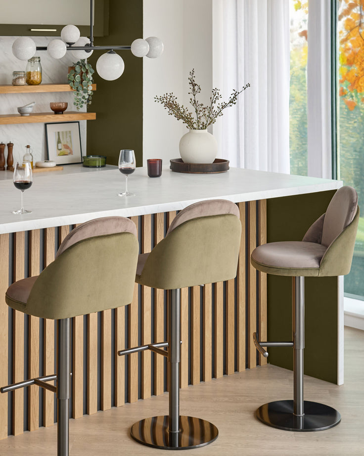 Myra gas lift bar stool in mocha and olive green velvet, shown in modern kitchen setting at counter.