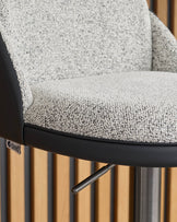 Myra gas lift bar stool with grey fabric seat, black faux leather trim, and natural wood fluted base, side detail view.
