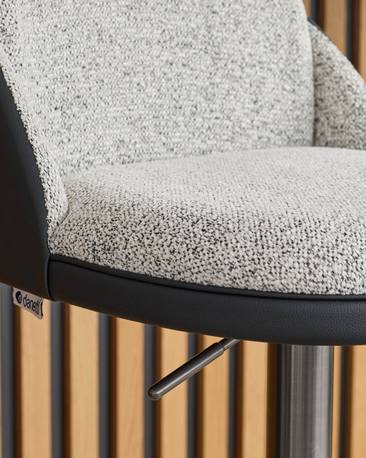 Myra gas lift bar stool with grey fabric seat, black faux leather trim, and natural wood fluted base, side detail view.
