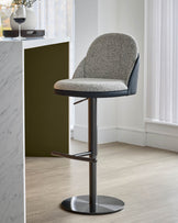 Myra gas lift bar stool in grey fabric and black faux leather, shown at an angle with chrome base and footrest.