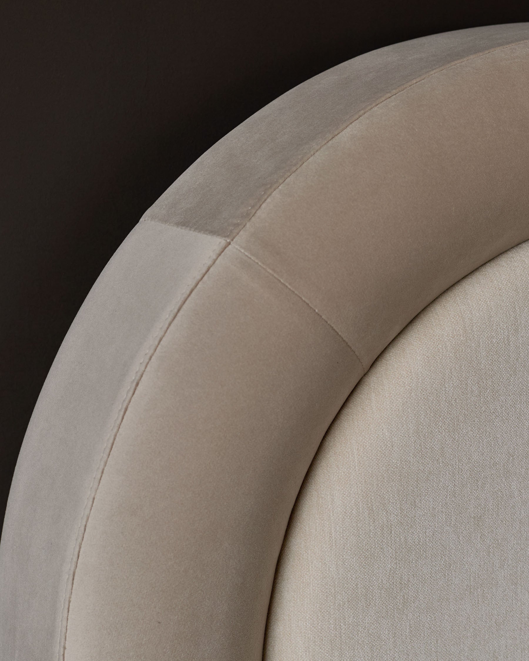 Naomi king-size ottoman bed in champagne velvet, close-up of curved headboard detail showing soft fabric texture.