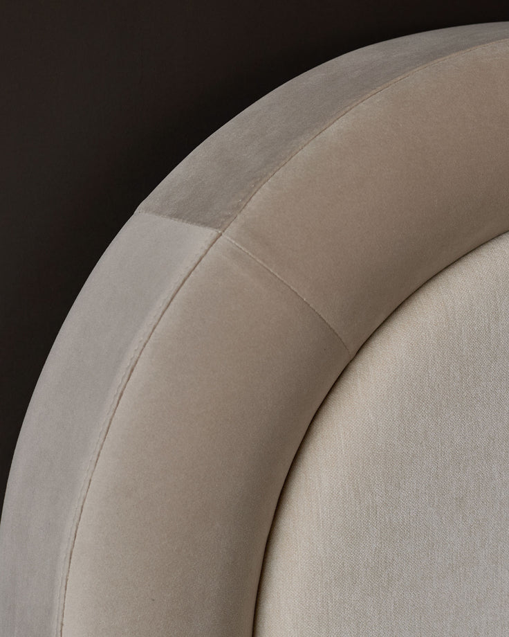 Naomi king-size ottoman bed in champagne velvet, close-up of curved headboard detail showing soft fabric texture.