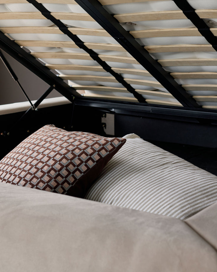 Naomi king-size ottoman bed in champagne velvet with natural wood slats and open storage base.
