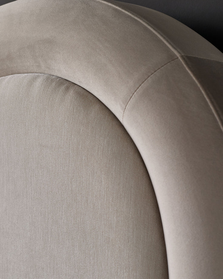 Naomi king-size ottoman bed in champagne velvet, close-up detail of curved headboard and upholstered finish.