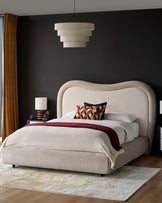 Naomi King-Size Ottoman Bed in champagne velvet with curved upholstered headboard, shown in a styled bedroom setting.