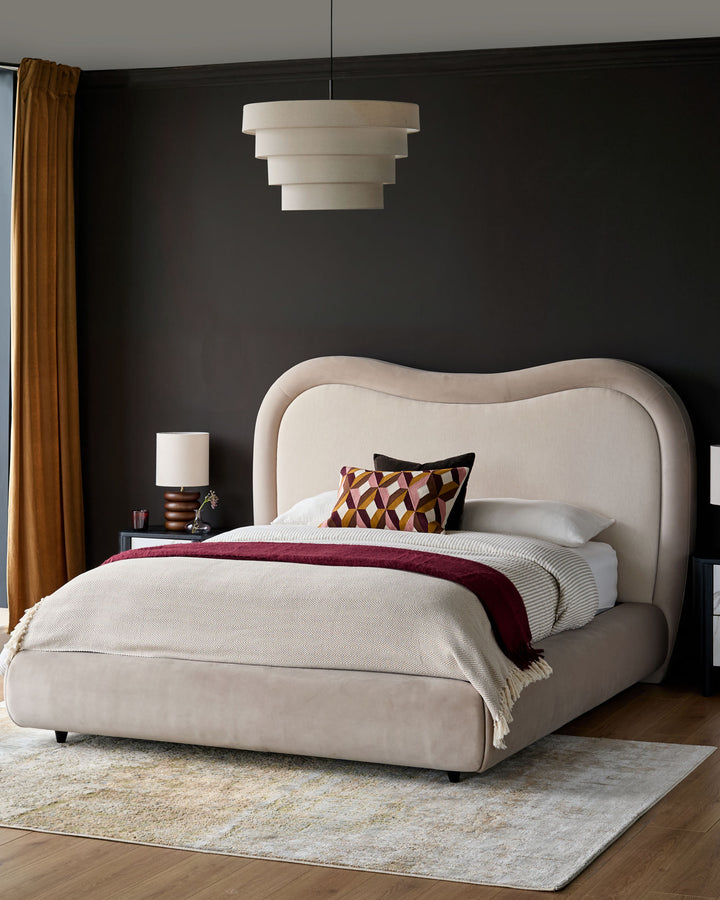 Naomi King-Size Ottoman Bed in champagne velvet with curved upholstered headboard, shown in a styled bedroom setting.