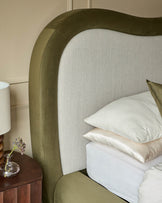 Naomi king-size ottoman bed in olive green velvet with natural linen headboard, styled with white bedding and nightstand.