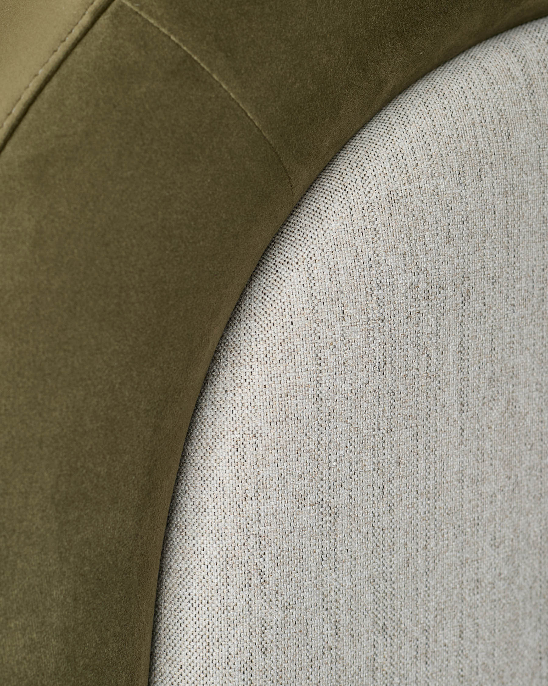 Naomi ottoman bed close-up showing olive green velvet headboard panel alongside natural linen upholstery detail.
