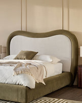 Naomi king-size ottoman bed in olive-green velvet with curved headboard and natural linen backrest, styled with bedding.
