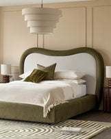 Naomi king-size ottoman bed in olive green velvet with curved headboard and cream upholstered backrest in bedroom setting.