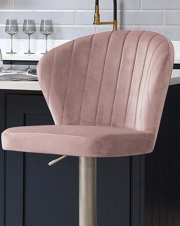 Harper velvet gas lift bar stool in blush pink with vertical channel stitching and brushed metal base.