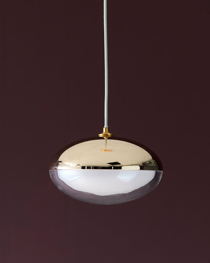Nina single pendant light with soft gold finish, featuring a dome-shaped glass shade with mirrored top and white diffuser.