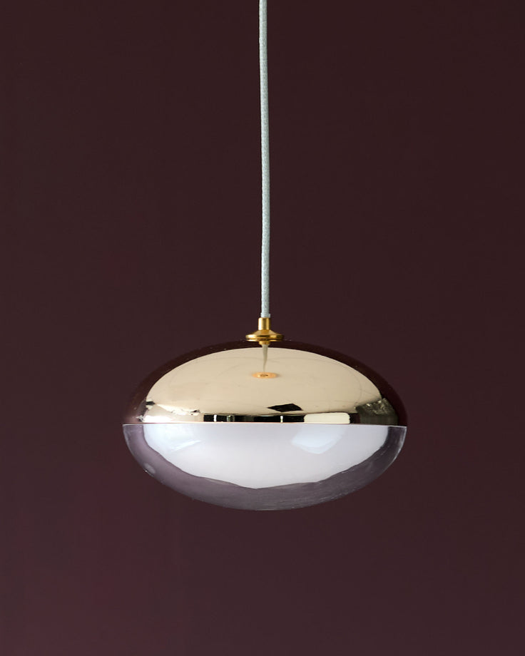 Nina single pendant light with soft gold finish, featuring a dome-shaped glass shade with mirrored top and white diffuser.