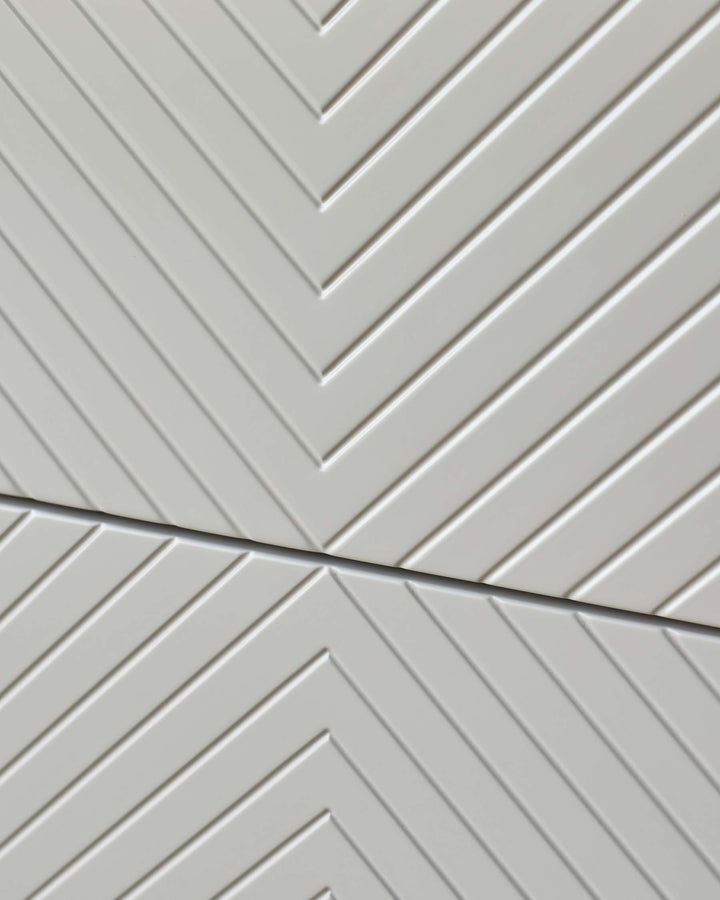 Close-up of modern white furniture with a subtle chevron pattern.