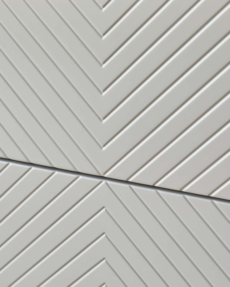 Close-up of modern white furniture with a subtle chevron pattern.