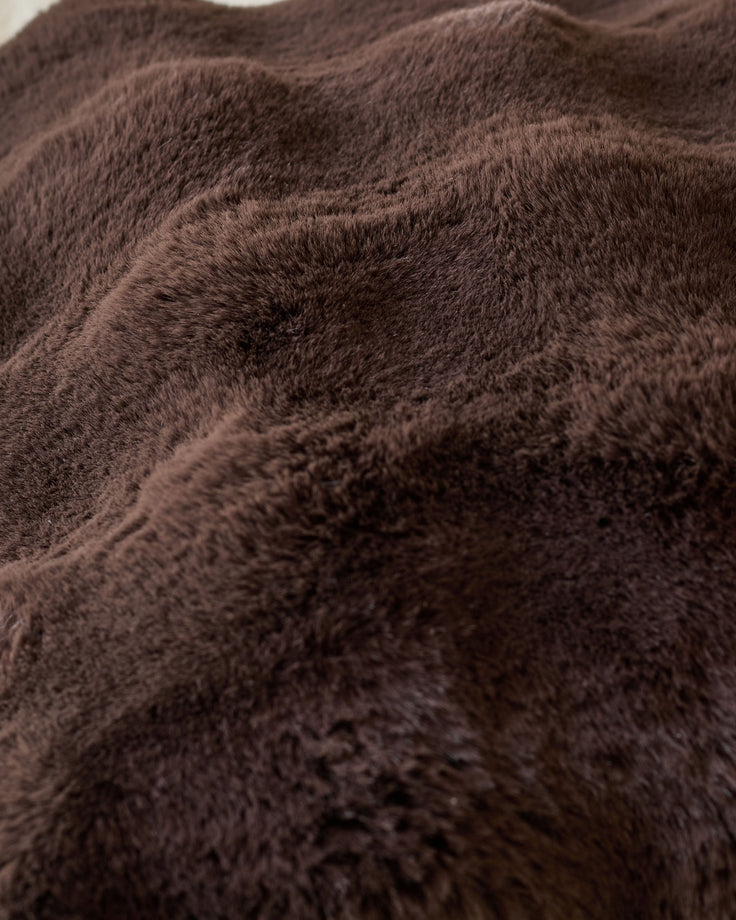 Close-up of Nova Large Cushion in chocolate brown showing soft, plush fabric texture and folds.