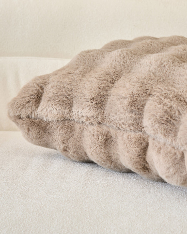 Large taupe cushion with gathered ruched texture and soft plush fabric, displayed at an angle on neutral background.