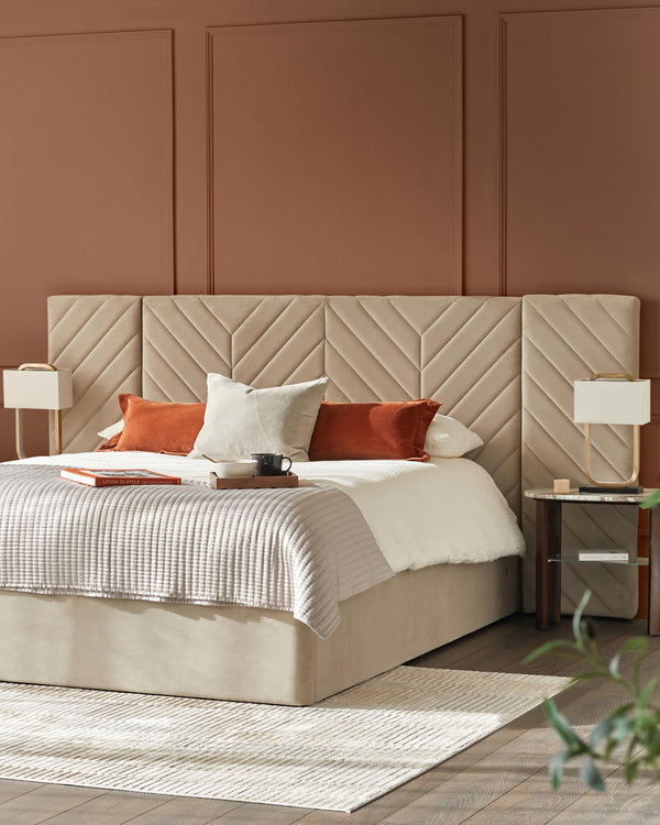 Stylish bedroom featuring a bed with a quilted headboard, bedside tables with lamps, and a neutral colour scheme.