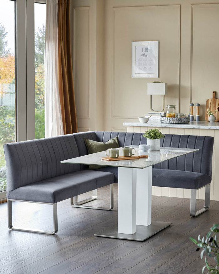 A stylish corner dining set with grey velvet seating and a modern white and glass table, perfect for a contemporary kitchen.